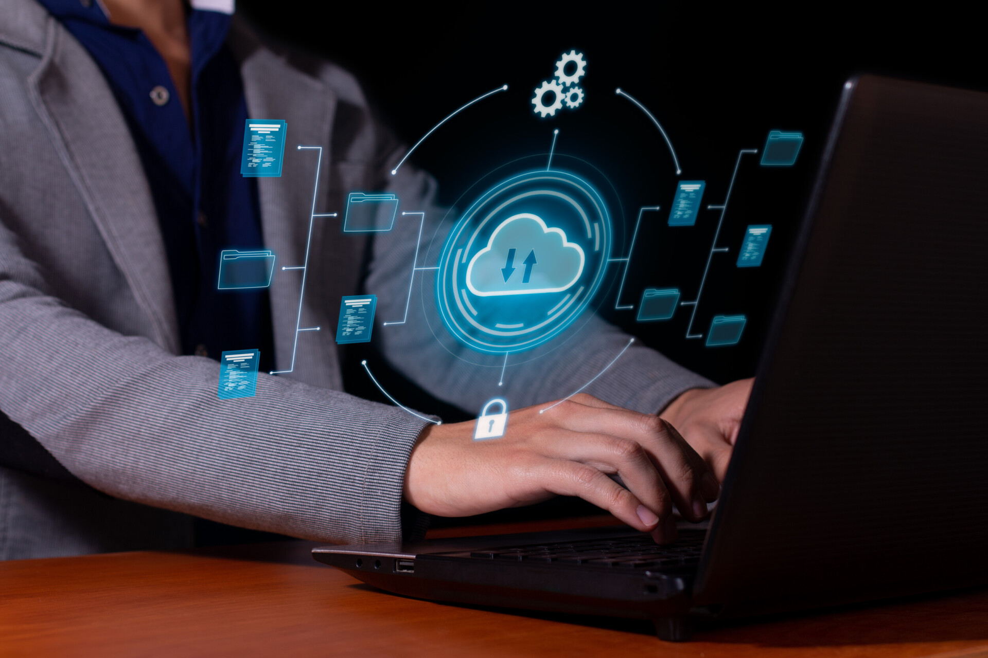 man uses cloud computing on his computer to transmit, store and backup important data and information.