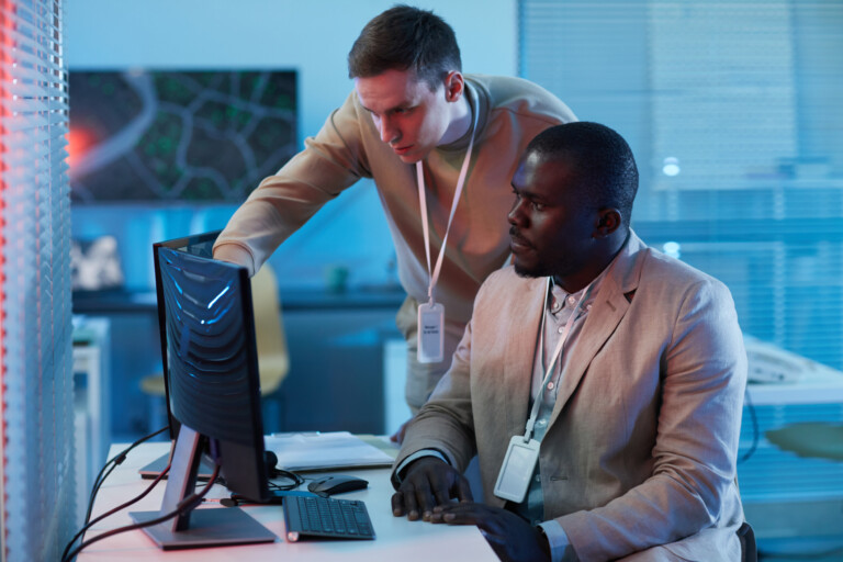 two people looking at surveillance camera footage in security center